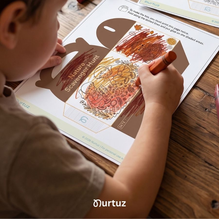 Creative Seed - Scavenger Hunt & Treasure Box 4 A child uses an orange crayon to color the Nurtuz Nature Scavenger Hunt printable box template on a wooden table before cutting and assembling it.